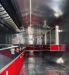 Interior de cocina en acero inoxidable con campana de extracción y gabinetes rojos