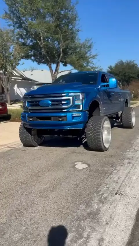 Lifted blue Ford F-250 on large polished wheels