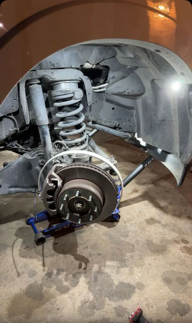 Front coilover and brake rotor on a truck with the wheel off