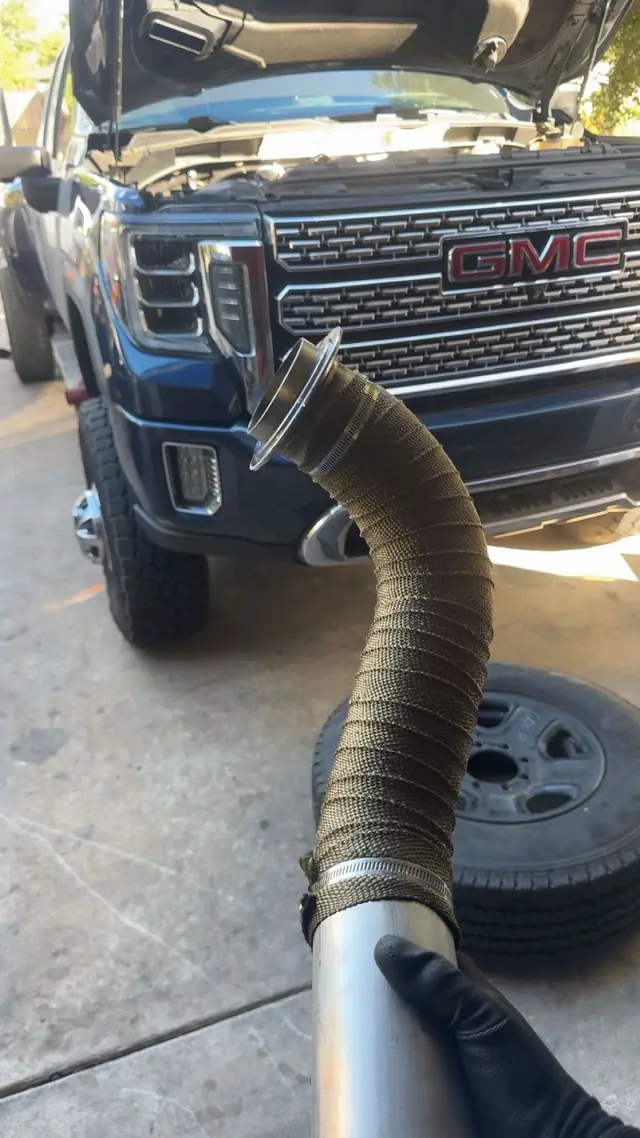 GMC pickup with a flexible exhaust pipe being fitted