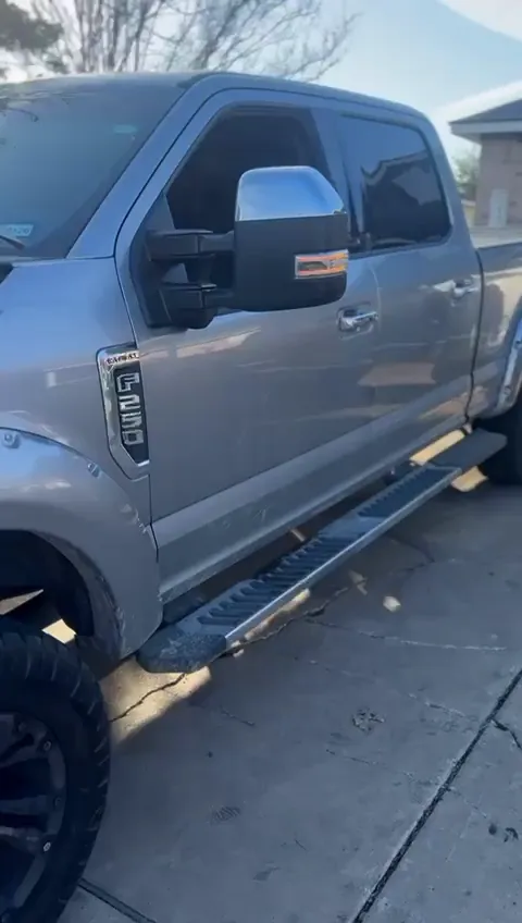 Grey Ford Super Duty on black wheels and all-terrain tires