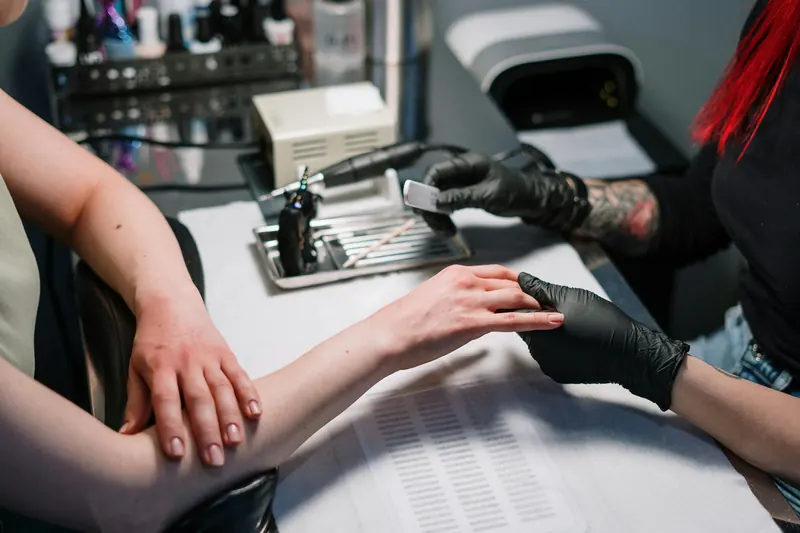 Mesa de manicura con clienta y manicurista trabajando