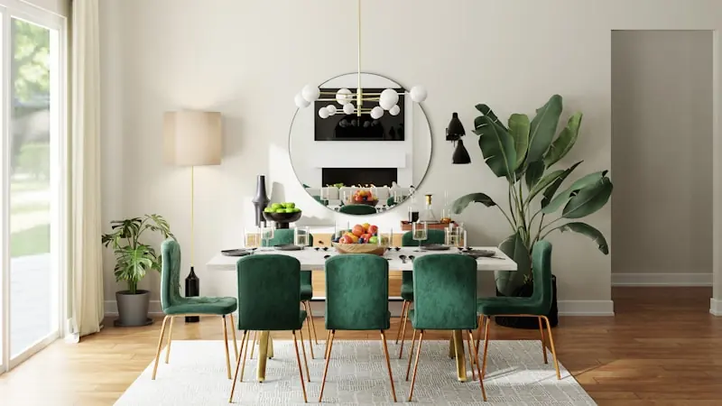 Comedor con sillas de terciopelo verde, espejo redondo y plantas